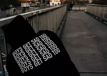 A person wearing a hoodie sweater that has the words 